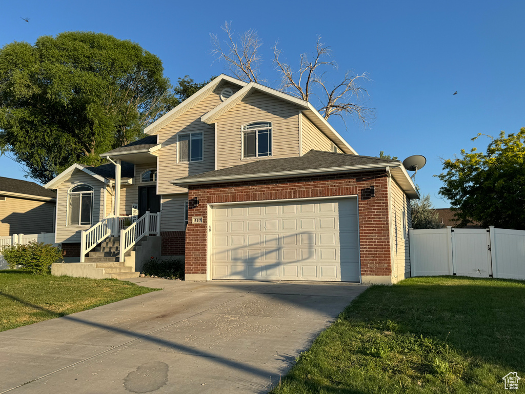 View of front of property with a garage and a front lawn