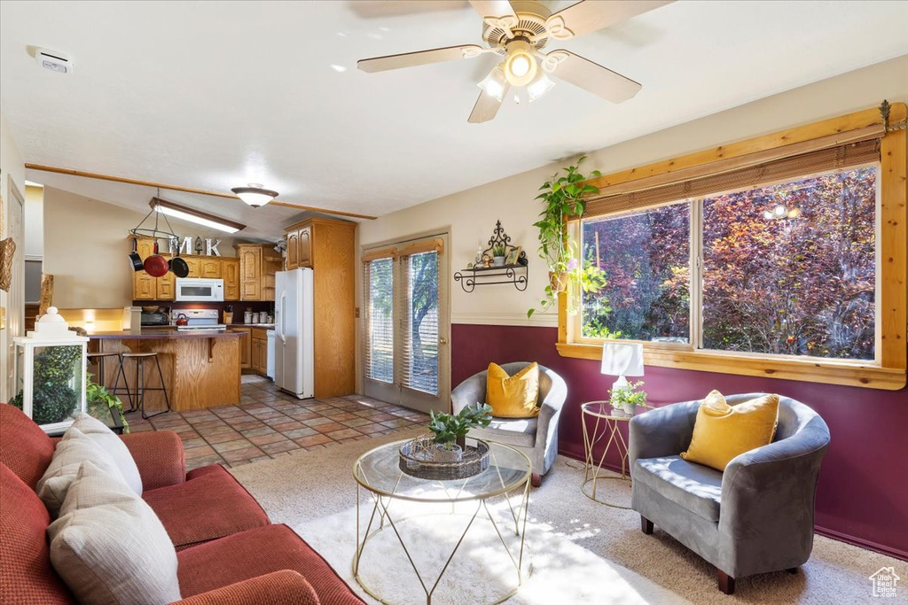 Living room featuring light tile patterned floors and ceiling fan