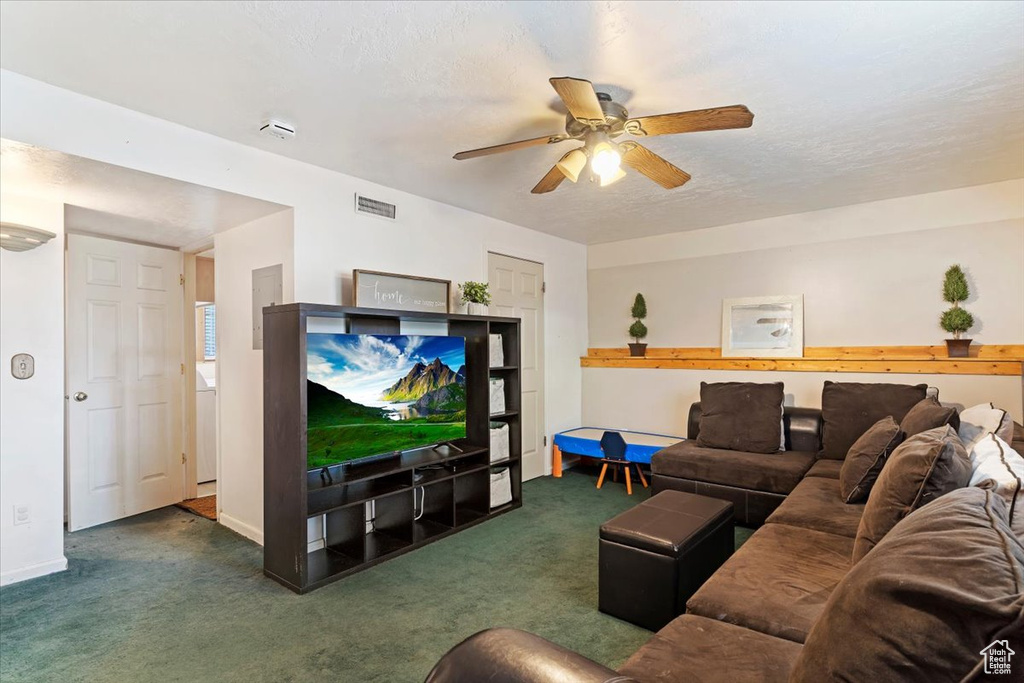 Carpeted living room with ceiling fan