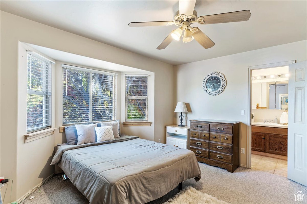 Tiled bedroom with sink, ensuite bath, and ceiling fan