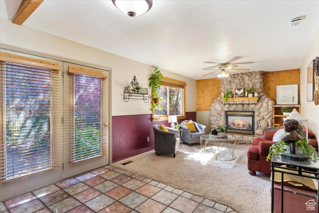 Tiled living room featuring a fireplace and ceiling fan