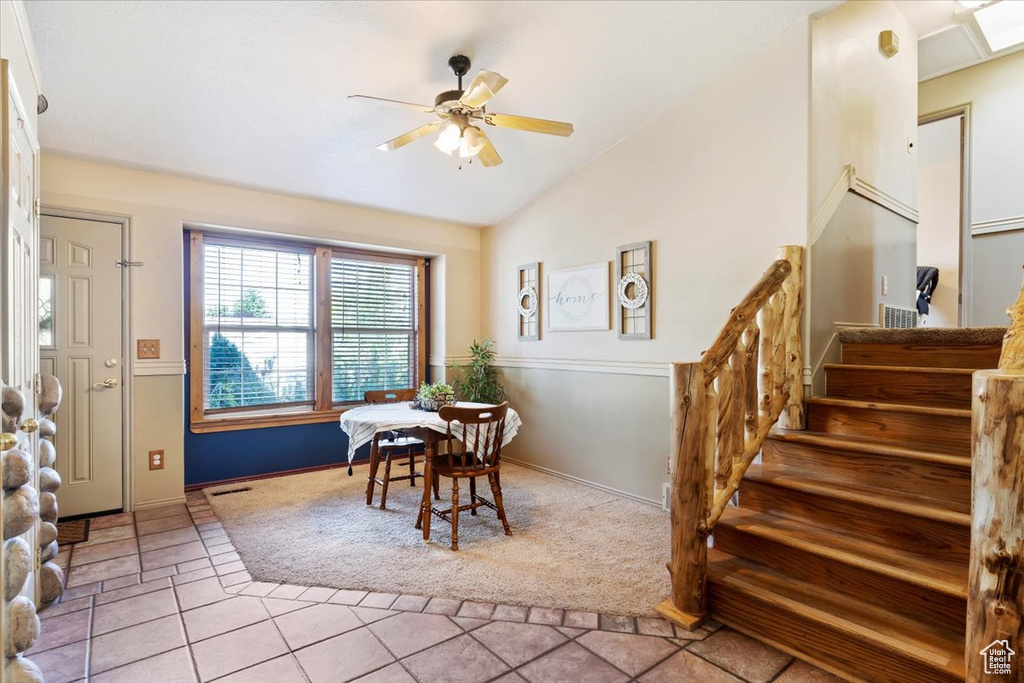 Tiled dining area featuring lofted ceiling and ceiling fan