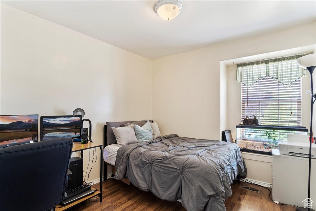 Bedroom with dark hardwood / wood-style floors