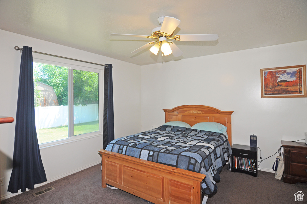 Carpeted bedroom featuring ceiling fan