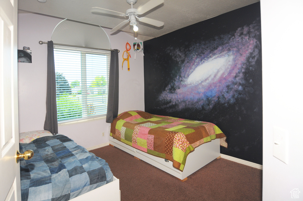 Bedroom with dark carpet and ceiling fan