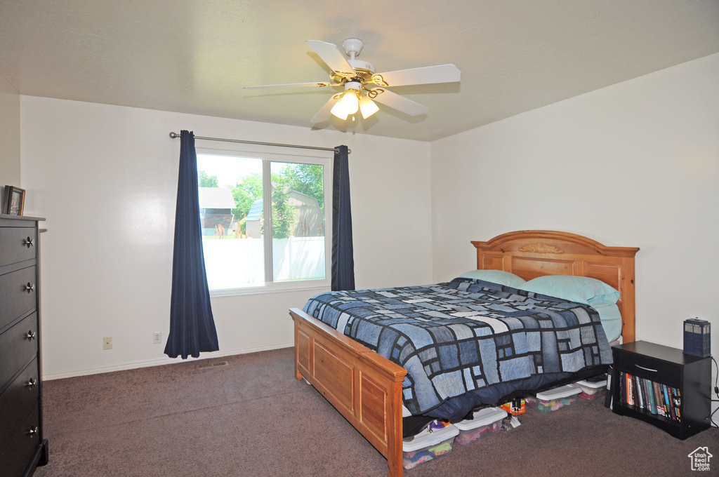 Bedroom featuring dark colored carpet and ceiling fan