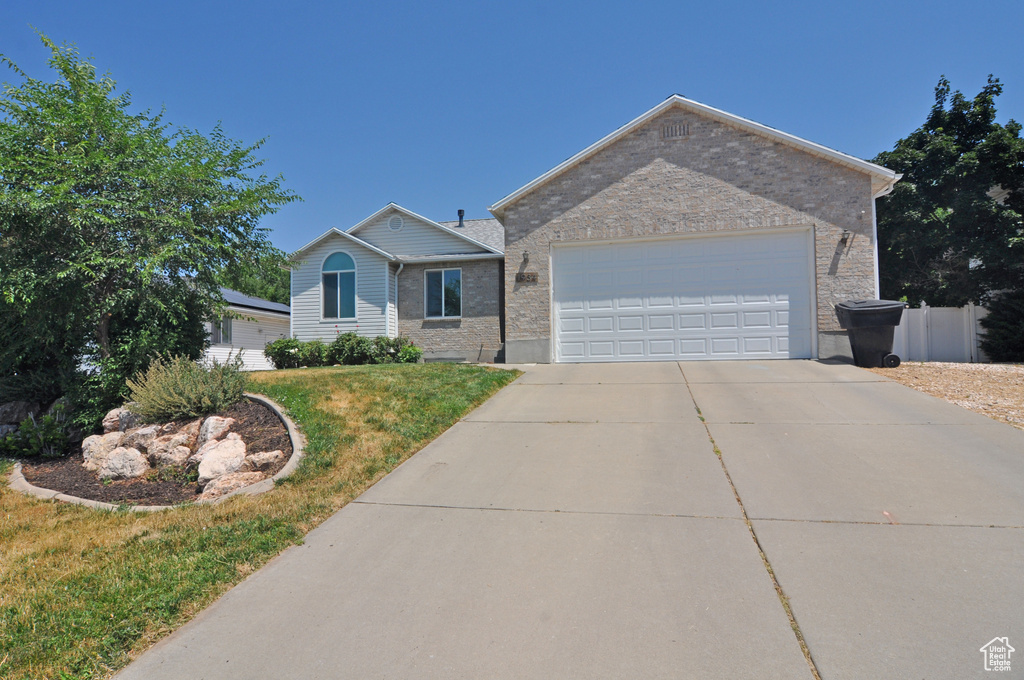 Ranch-style house with a garage and a front yard