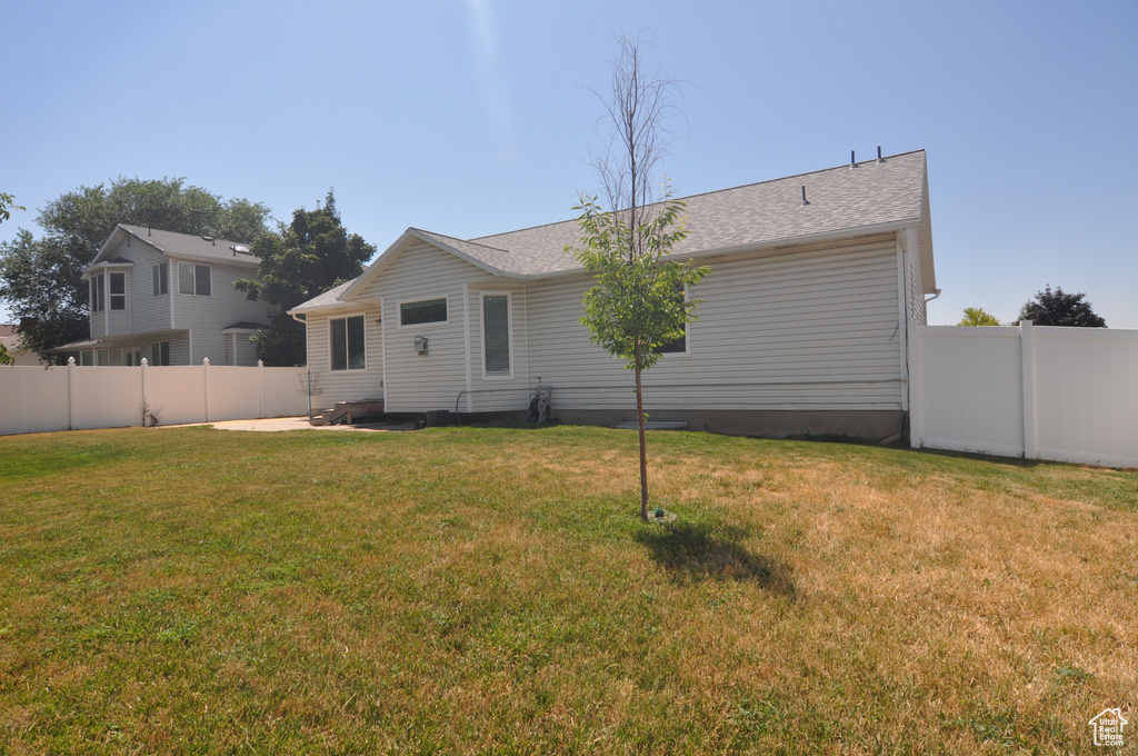 Rear view of property featuring a lawn