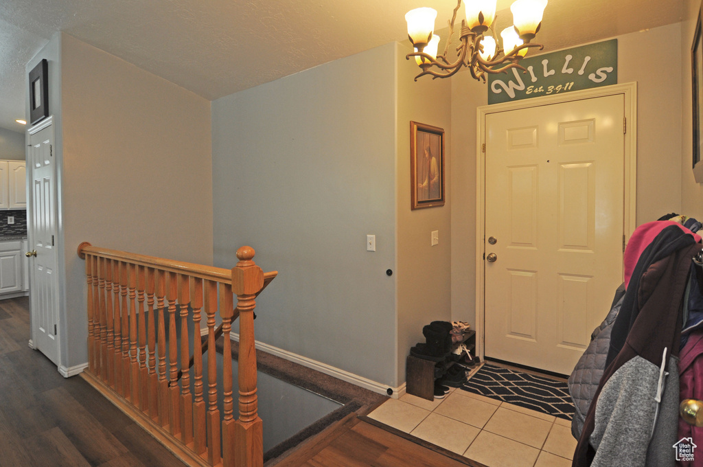 Foyer entrance with an inviting chandelier and wood-type flooring