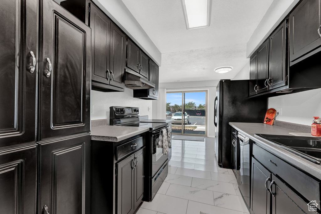 Kitchen with light tile patterned flooring, electric range, and dishwasher