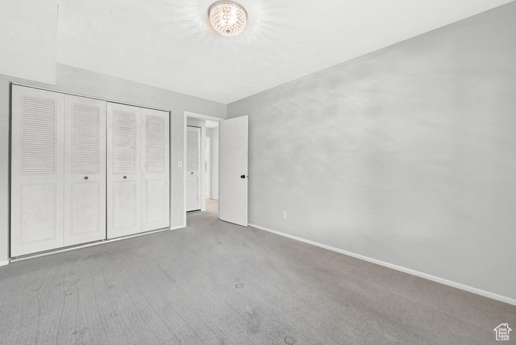 Unfurnished bedroom with dark carpet and a closet