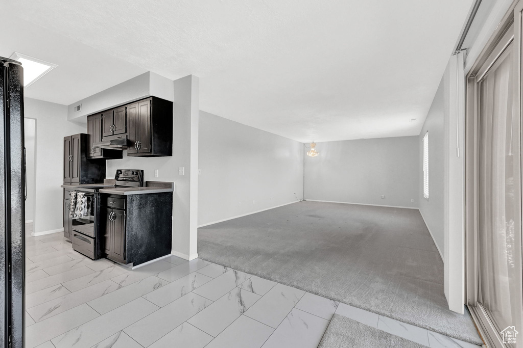 Kitchen with light tile patterned flooring and electric range