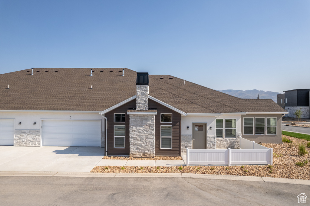 View of front of property with a mountain view and a garage