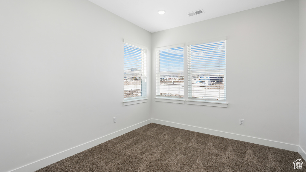 Empty room featuring dark carpet