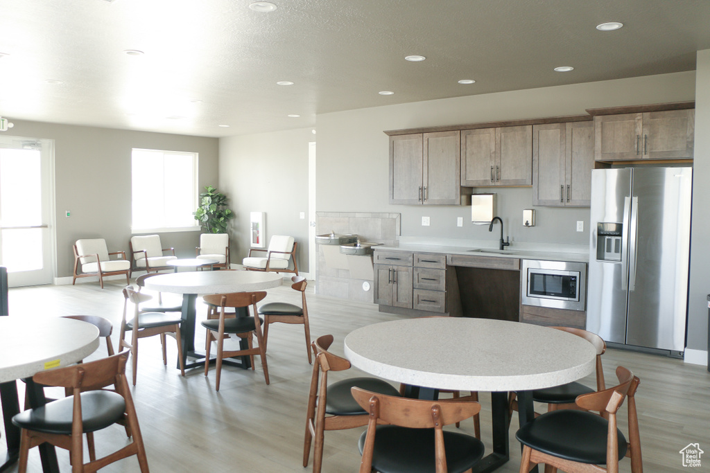 Kitchen with light hardwood / wood-style floors, appliances with stainless steel finishes, and sink