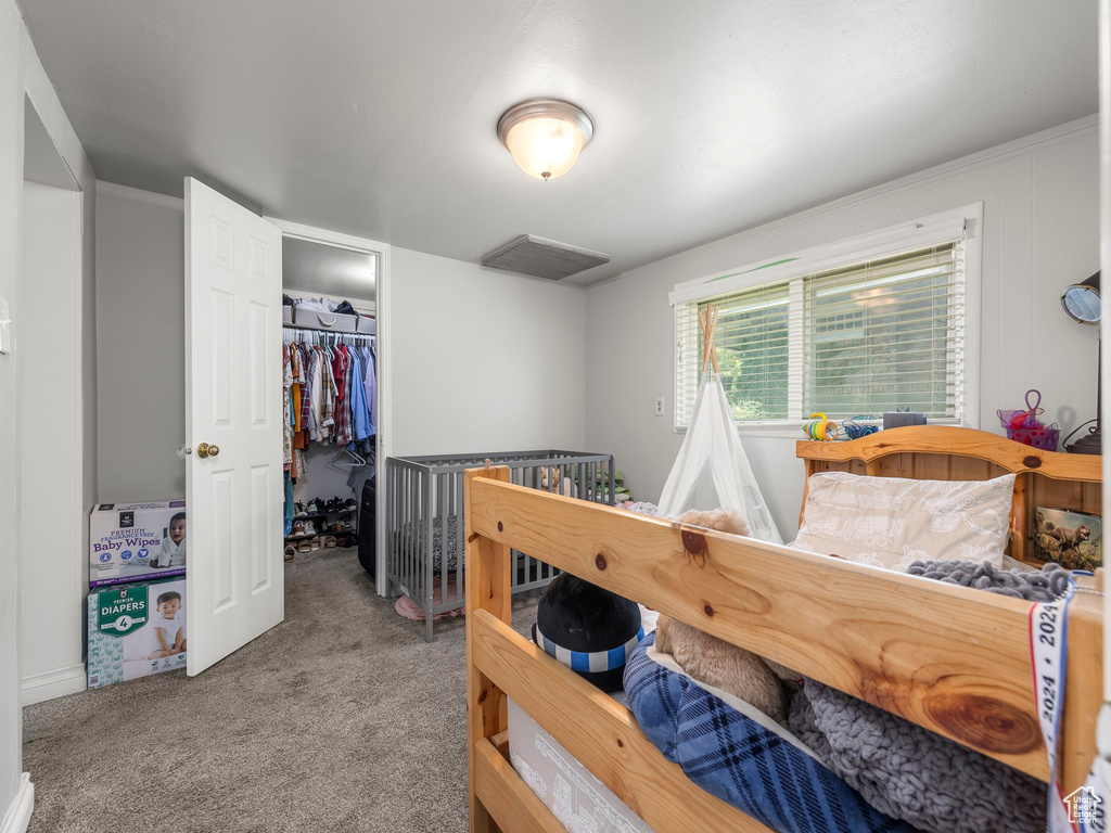 Bedroom featuring a closet, carpet flooring, and a spacious closet