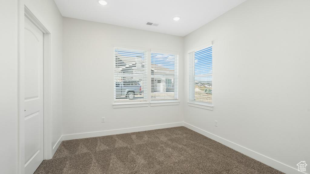 Spare room with dark colored carpet