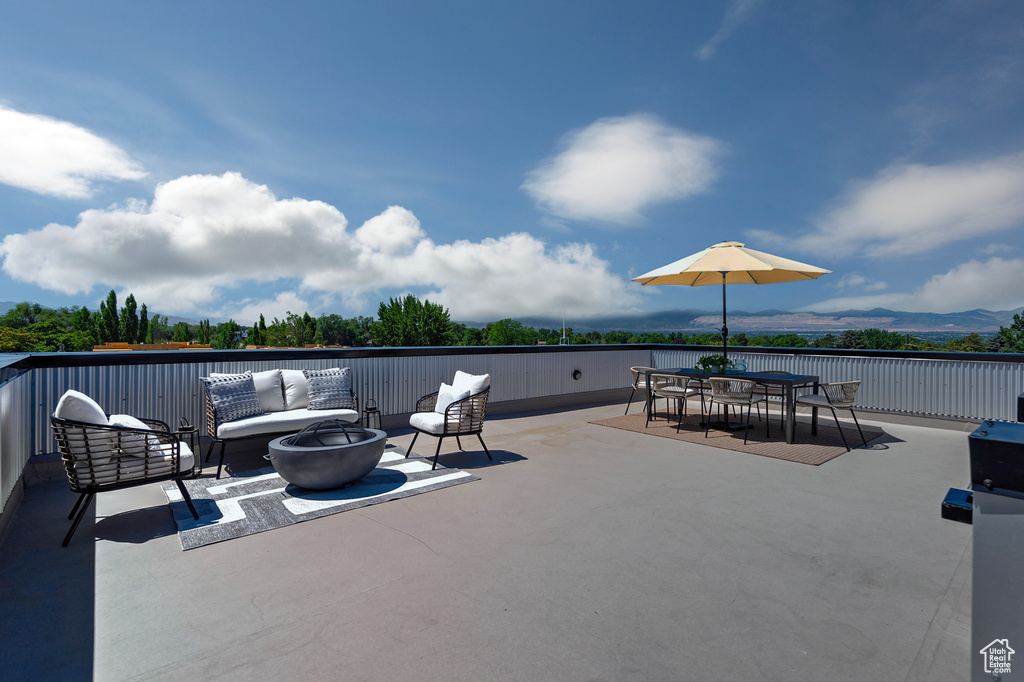 View of patio / terrace featuring an outdoor living space with a fire pit and a mountain view