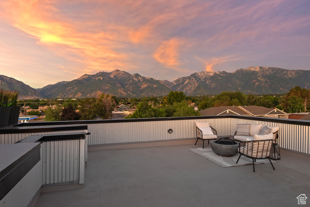 Patio terrace at dusk with a mountain view and a balcony