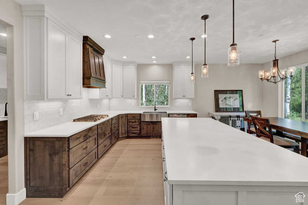 Kitchen with hanging light fixtures, tasteful backsplash, and a kitchen island