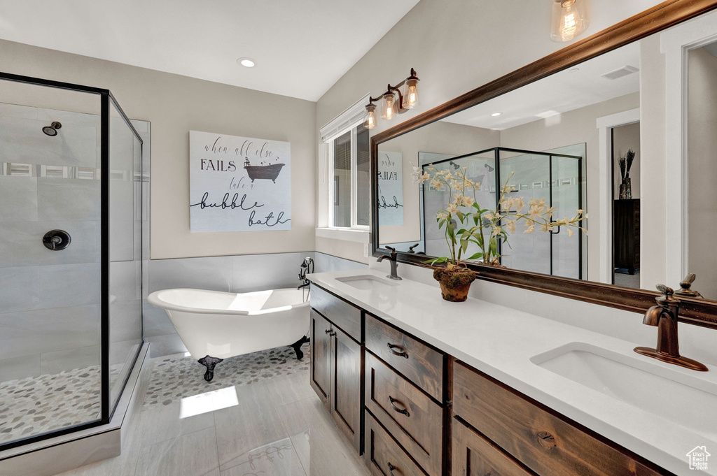 Bathroom with tile patterned flooring, independent shower and bath, and dual bowl vanity