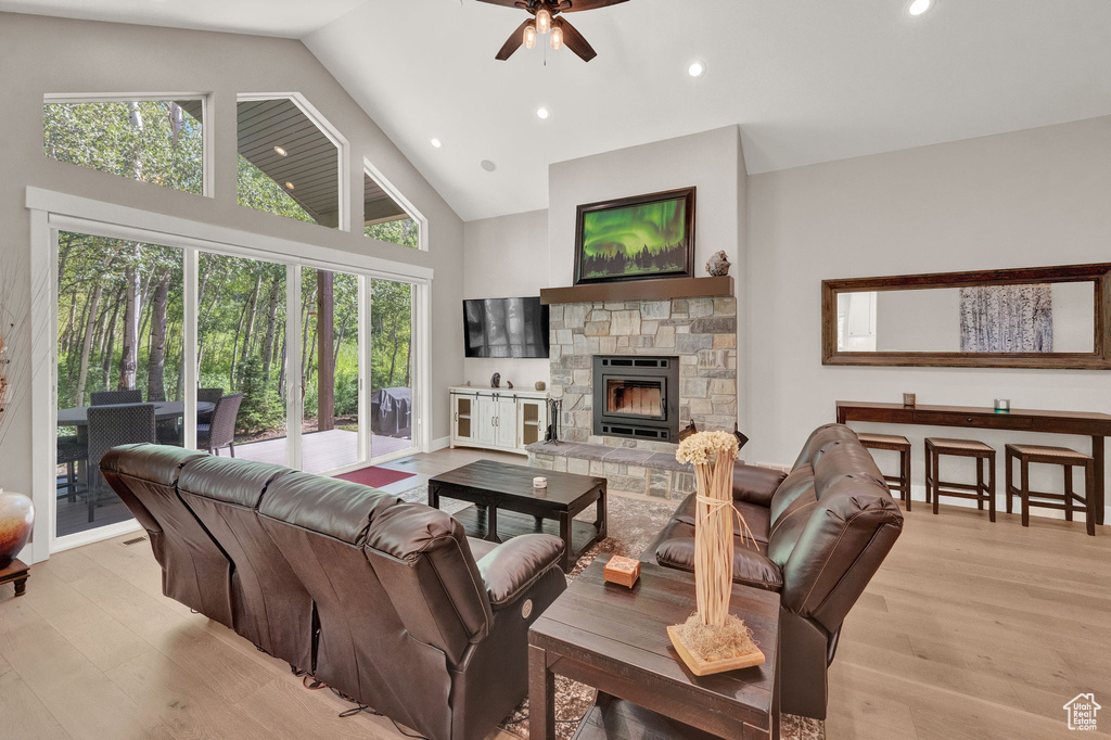 Living room featuring ceiling fan, a fireplace, light hardwood / wood-style floors, and plenty of natural light