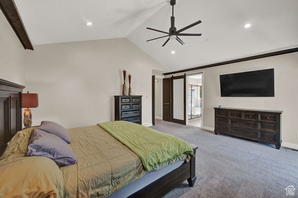 Bedroom with connected bathroom, a barn door, carpet floors, and ceiling fan