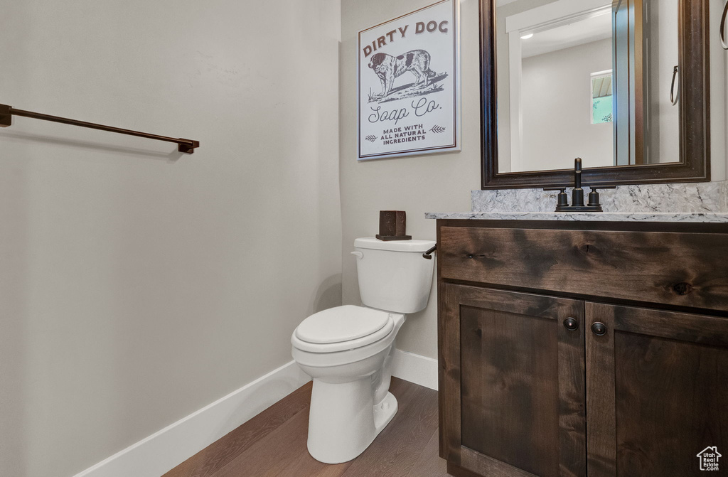 Bathroom with toilet, hardwood / wood-style floors, and vanity