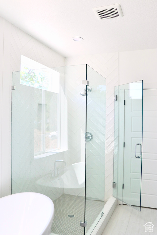 Bathroom featuring a shower with door and tile patterned flooring