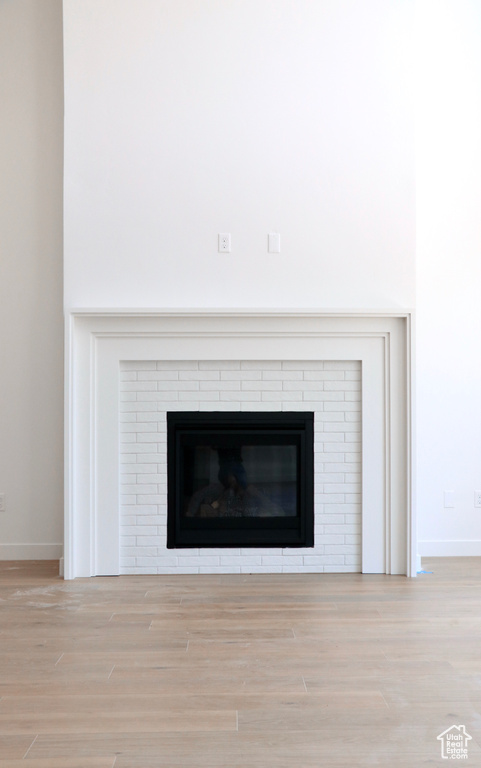 Room details with a brick fireplace and hardwood / wood-style floors