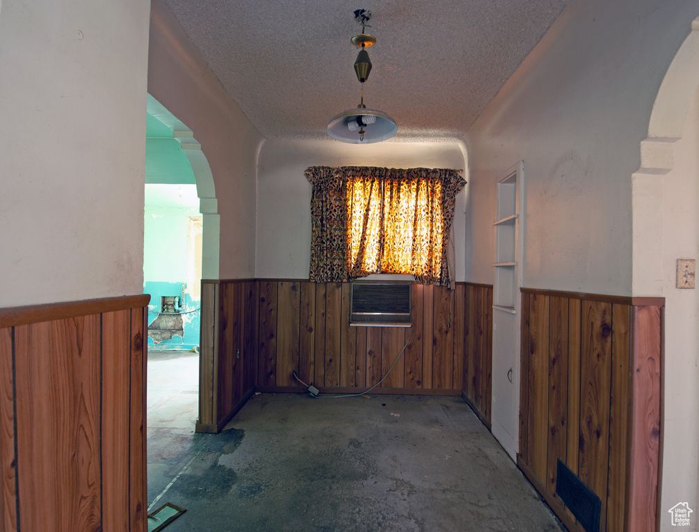 Corridor featuring a textured ceiling and cooling unit