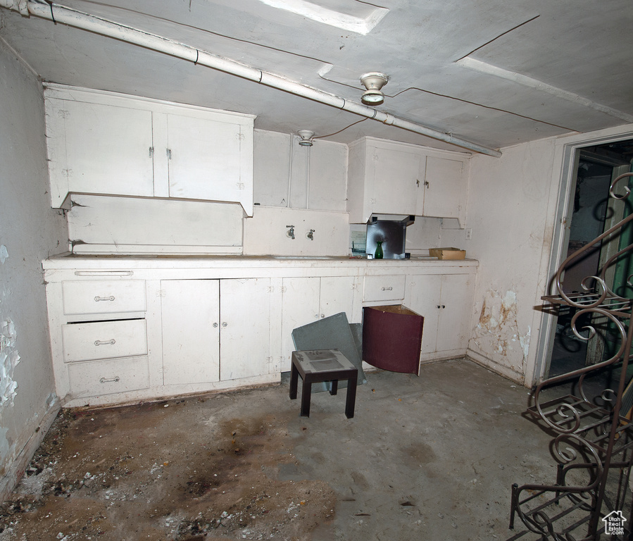 Interior space featuring white cabinets and concrete floors
