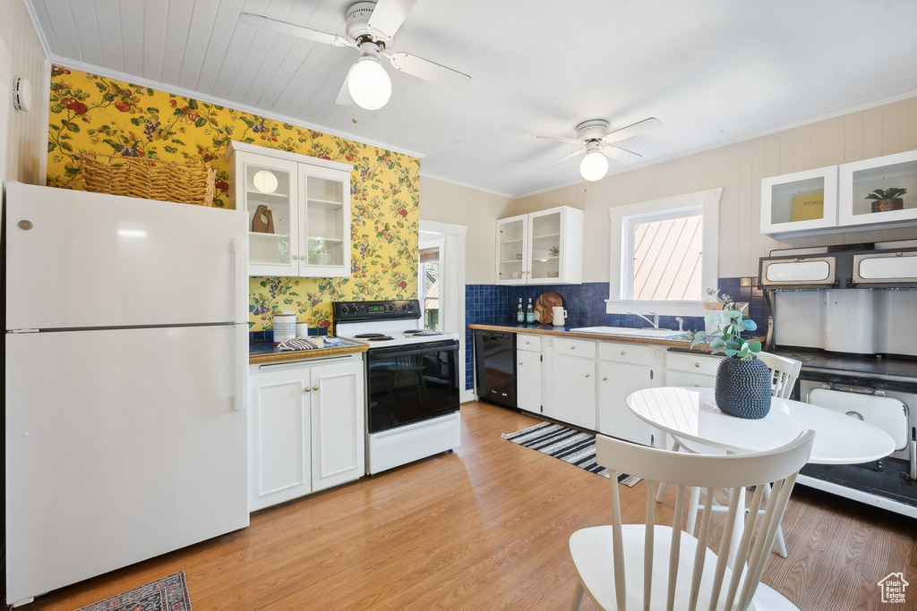 Kitchen with white cabinetry, light hardwood / wood-style flooring, ceiling fan, and white appliances