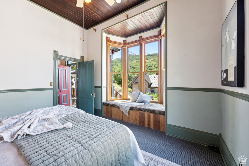 Carpeted bedroom featuring wood ceiling, ceiling fan, and a towering ceiling