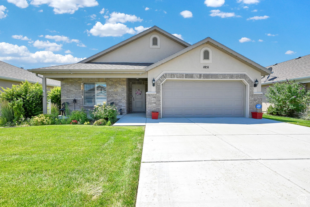 View of front of property with a garage and a front yard