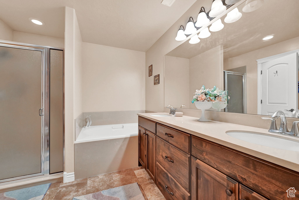 Bathroom featuring tile patterned floors, separate shower and tub, and dual bowl vanity