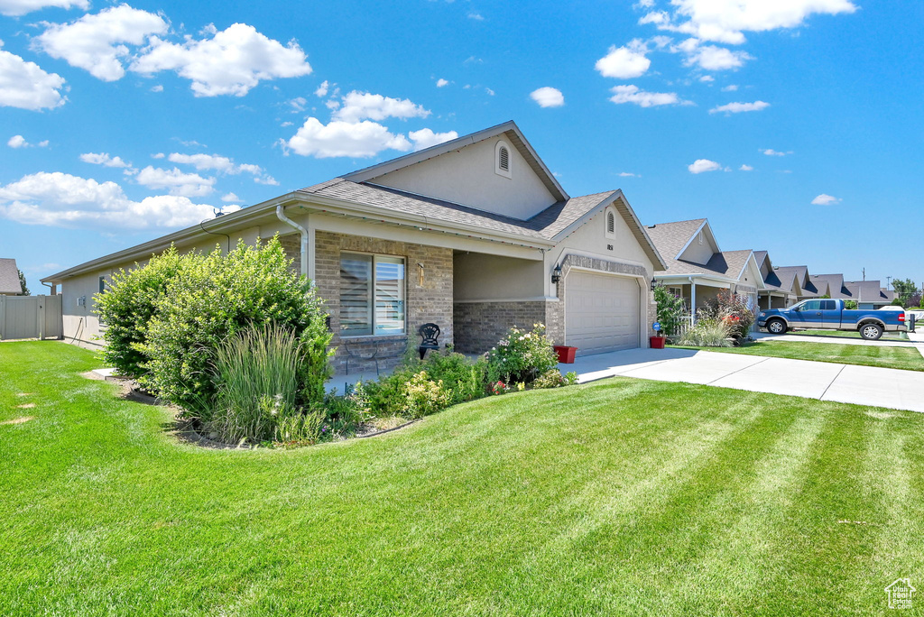 View of front of home with a garage and a front lawn