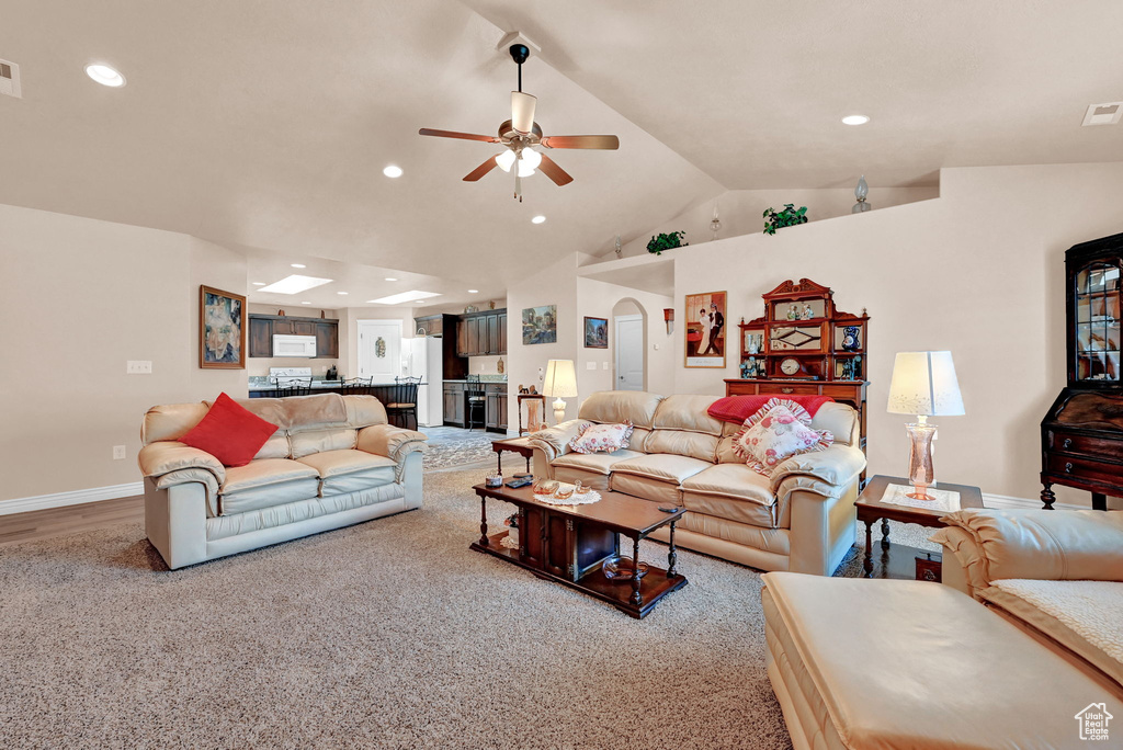 Living room featuring ceiling fan, lofted ceiling, and hardwood / wood-style floors