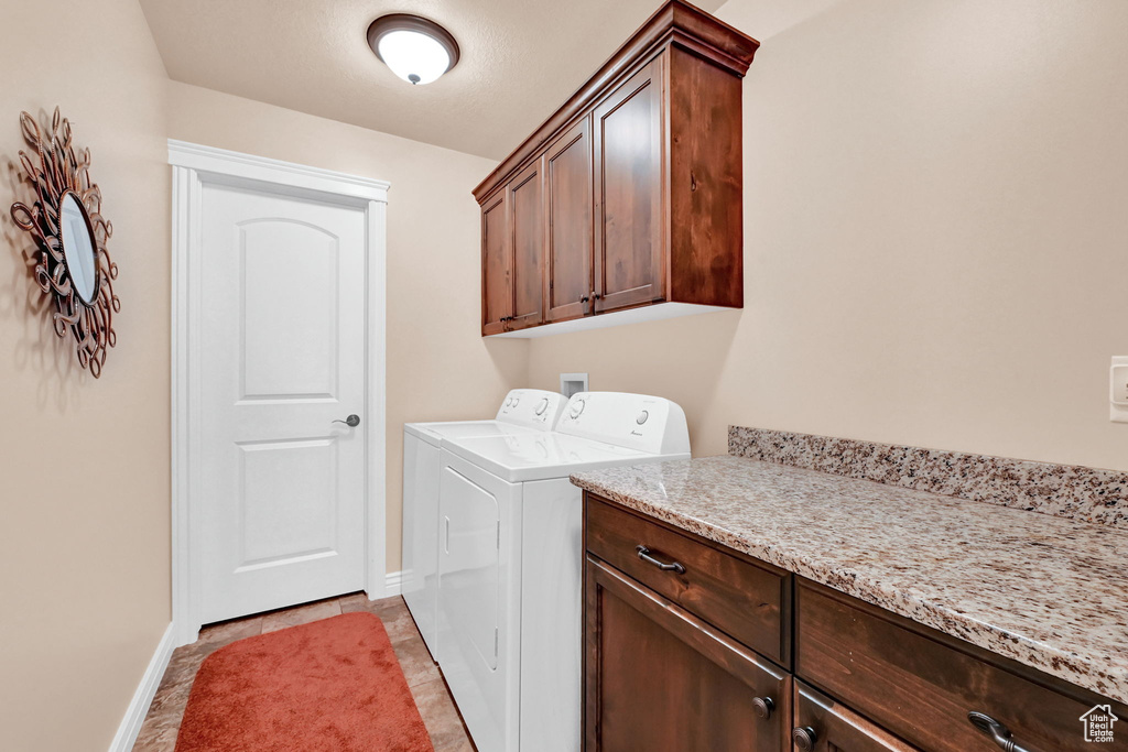 Laundry room with cabinets, washer and dryer, and light tile patterned floors