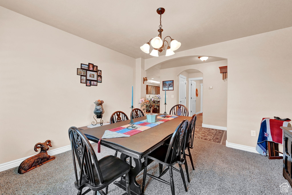 Dining room with carpet floors and an inviting chandelier