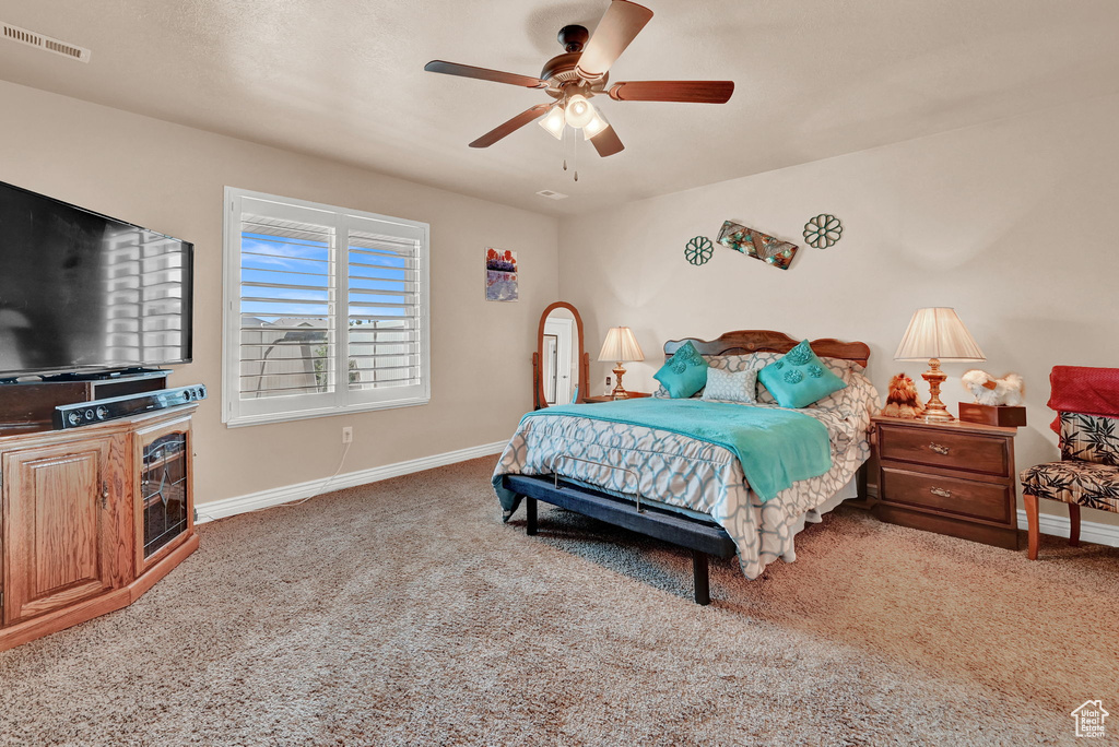 Carpeted bedroom featuring ceiling fan