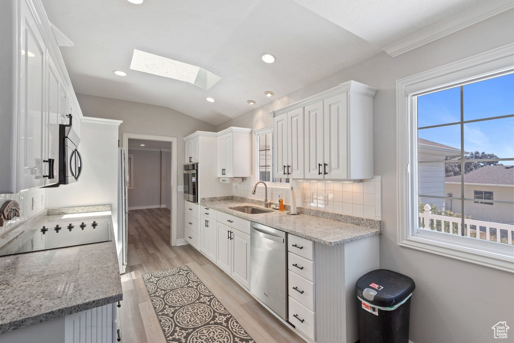 Kitchen with sink, white cabinets, plenty of natural light, and stainless steel appliances