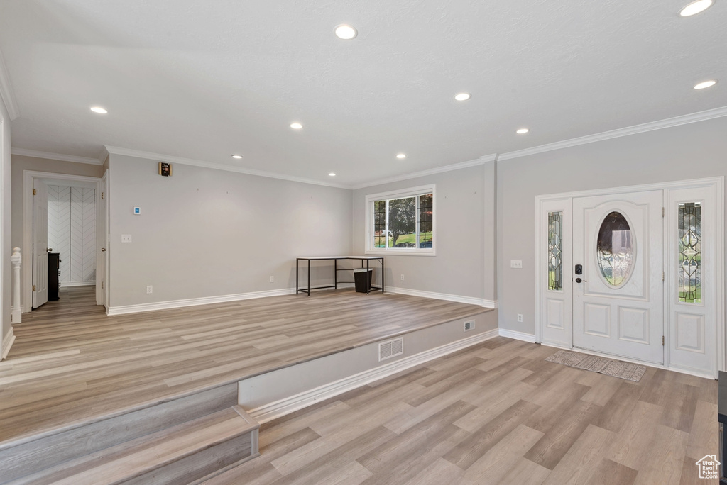 Foyer featuring ornamental molding and light hardwood / wood-style floors