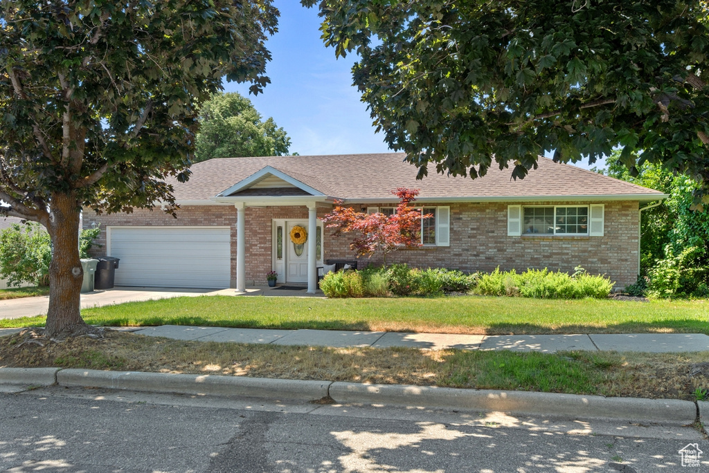 View of front of property with a garage and a front lawn