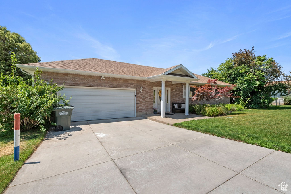 Single story home with a garage and a front yard