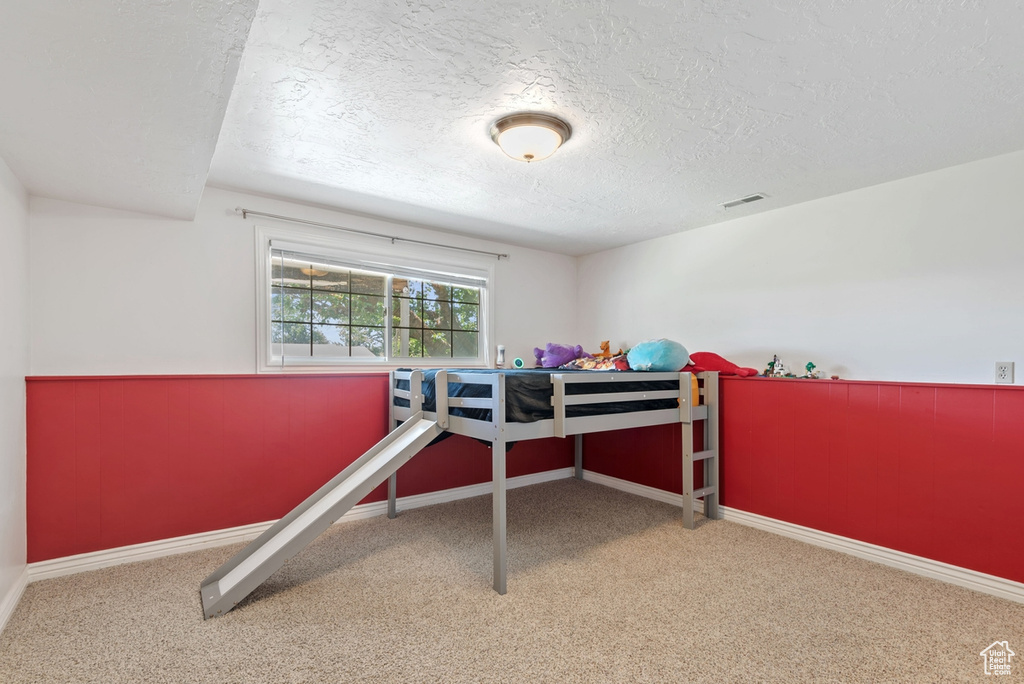 Bedroom featuring carpet floors and a textured ceiling