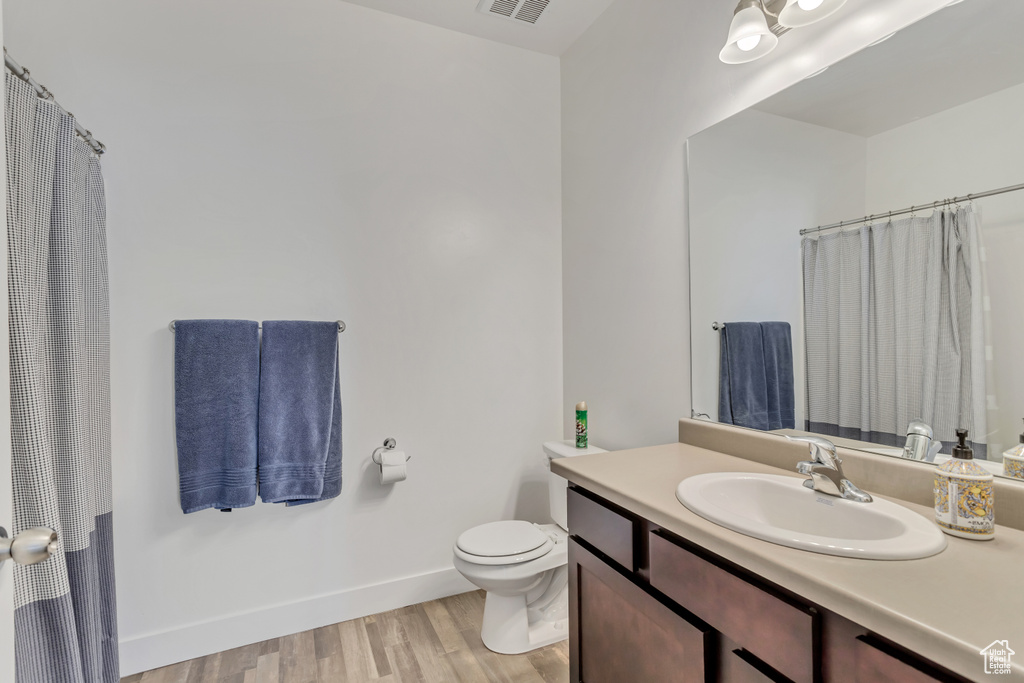 Bathroom with vanity, toilet, and wood-type flooring