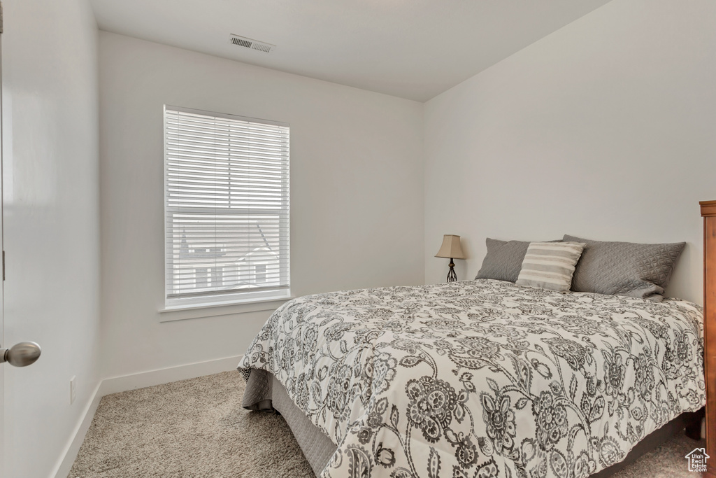 Carpeted bedroom with multiple windows