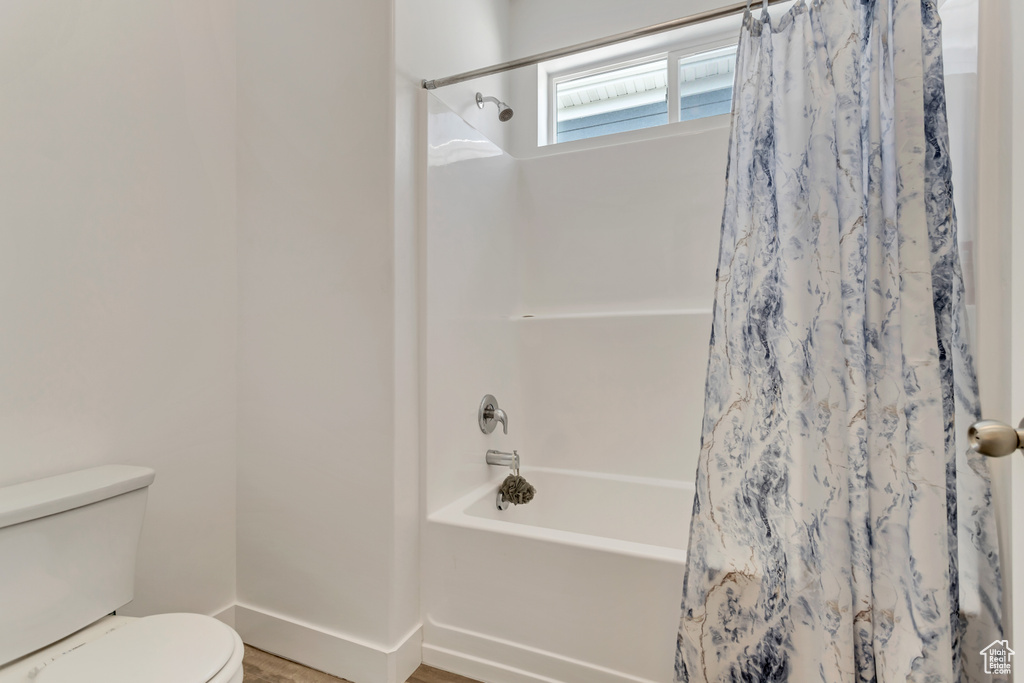 Bathroom with shower / bath combo with shower curtain and toilet