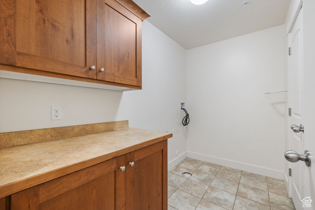 Washroom featuring washer hookup and light tile patterned floors